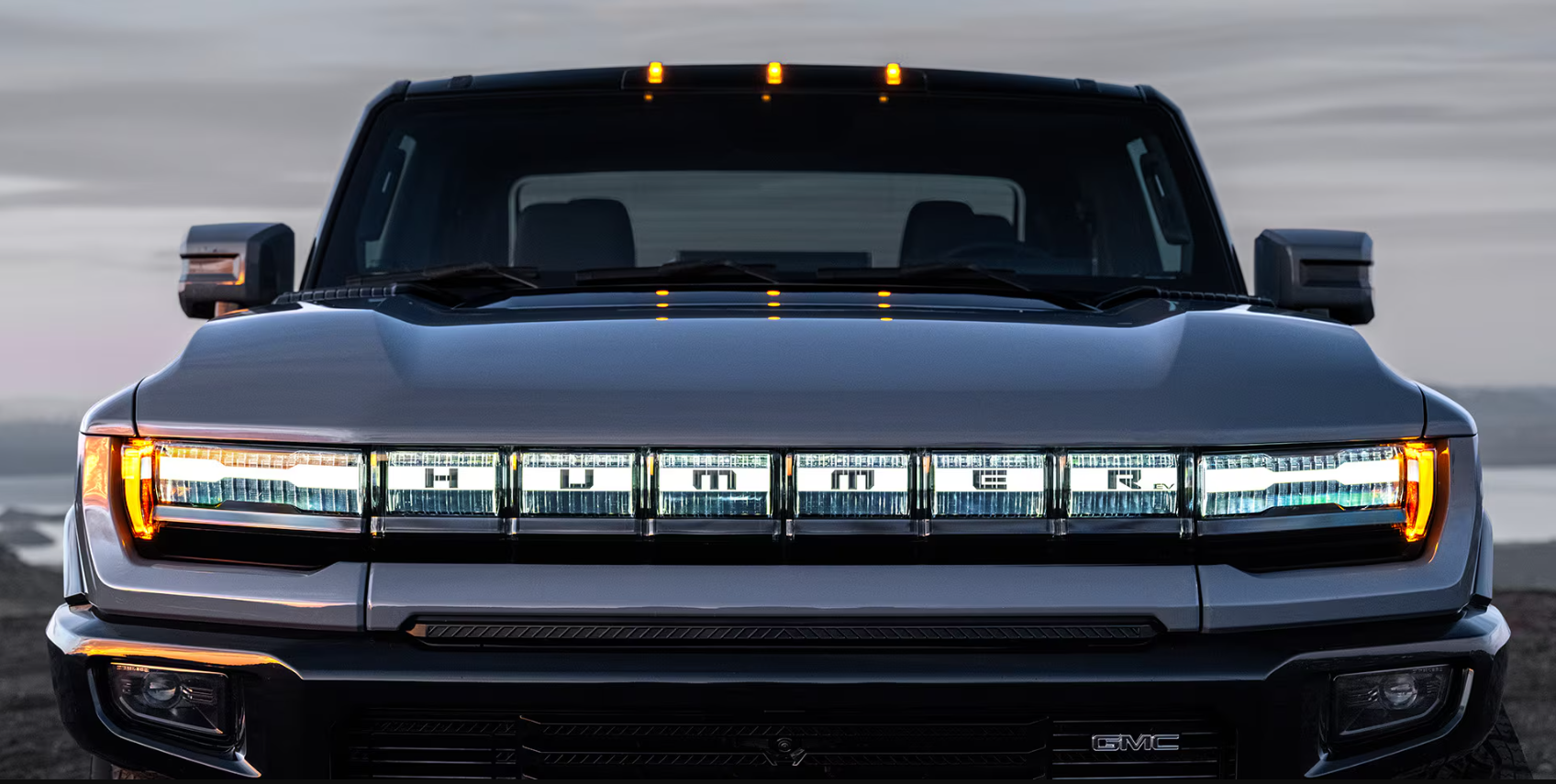 Close-up of Hummer EV front grille with illuminated “HUMMER” badging.